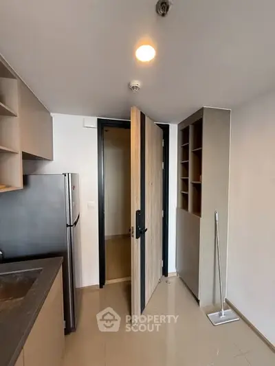 Modern kitchen with open door and sleek appliances in compact space