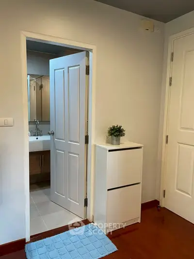 Modern bathroom entrance with sleek white doors and stylish vanity
