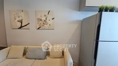 Cozy living room with modern fridge and elegant wall art, perfect for stylish urban living.