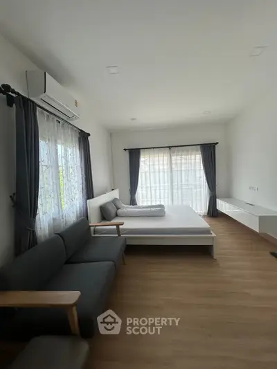 Spacious bedroom with modern decor and natural light
