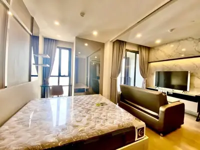 Modern bedroom with stylish decor and large windows offering natural light