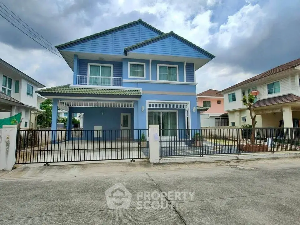 Charming blue two-story house with spacious driveway and modern design in a serene neighborhood.