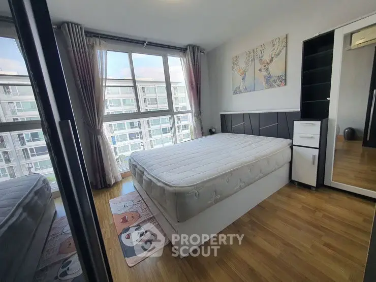 Bright bedroom with large window and modern decor in urban apartment