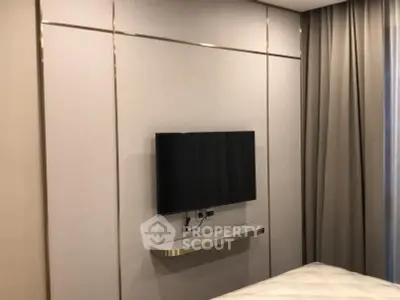 Modern bedroom with wall-mounted TV and elegant decor