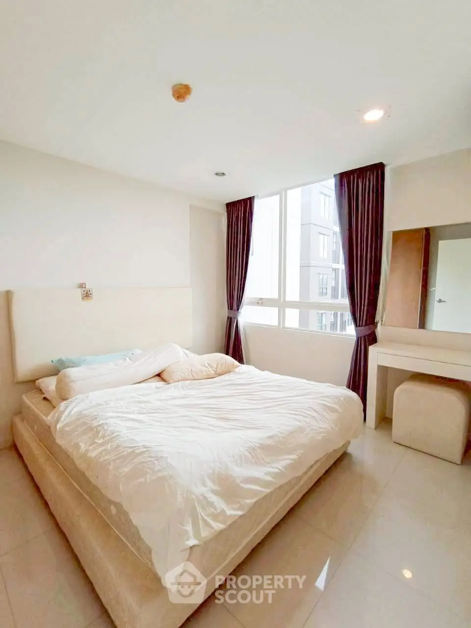 Spacious bedroom with large window and elegant curtains in modern apartment