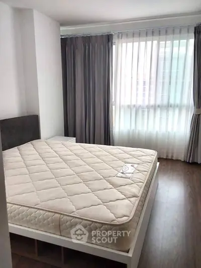 Spacious bedroom with large window and modern decor
