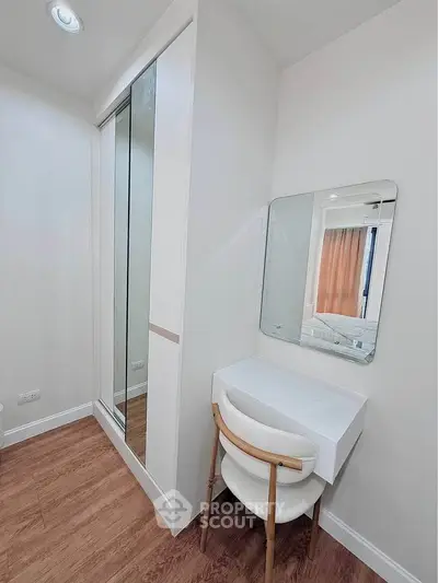 Modern bedroom with sleek vanity and mirrored closet doors