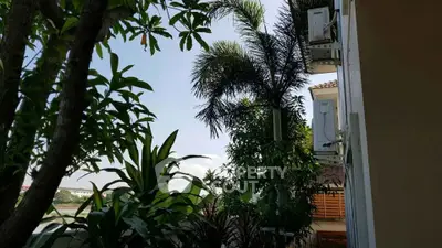 Lush garden view from a residential balcony with tropical plants and serene surroundings.