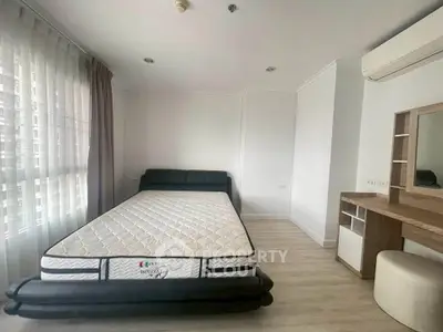 Spacious bedroom with modern furnishings and natural light in a stylish apartment.