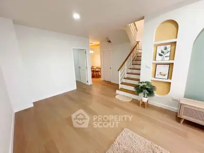 Spacious modern living room with wooden flooring and stylish staircase