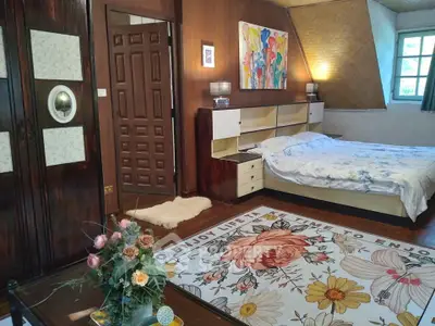 Charming bedroom with unique decor and floral rug in cozy real estate listing.