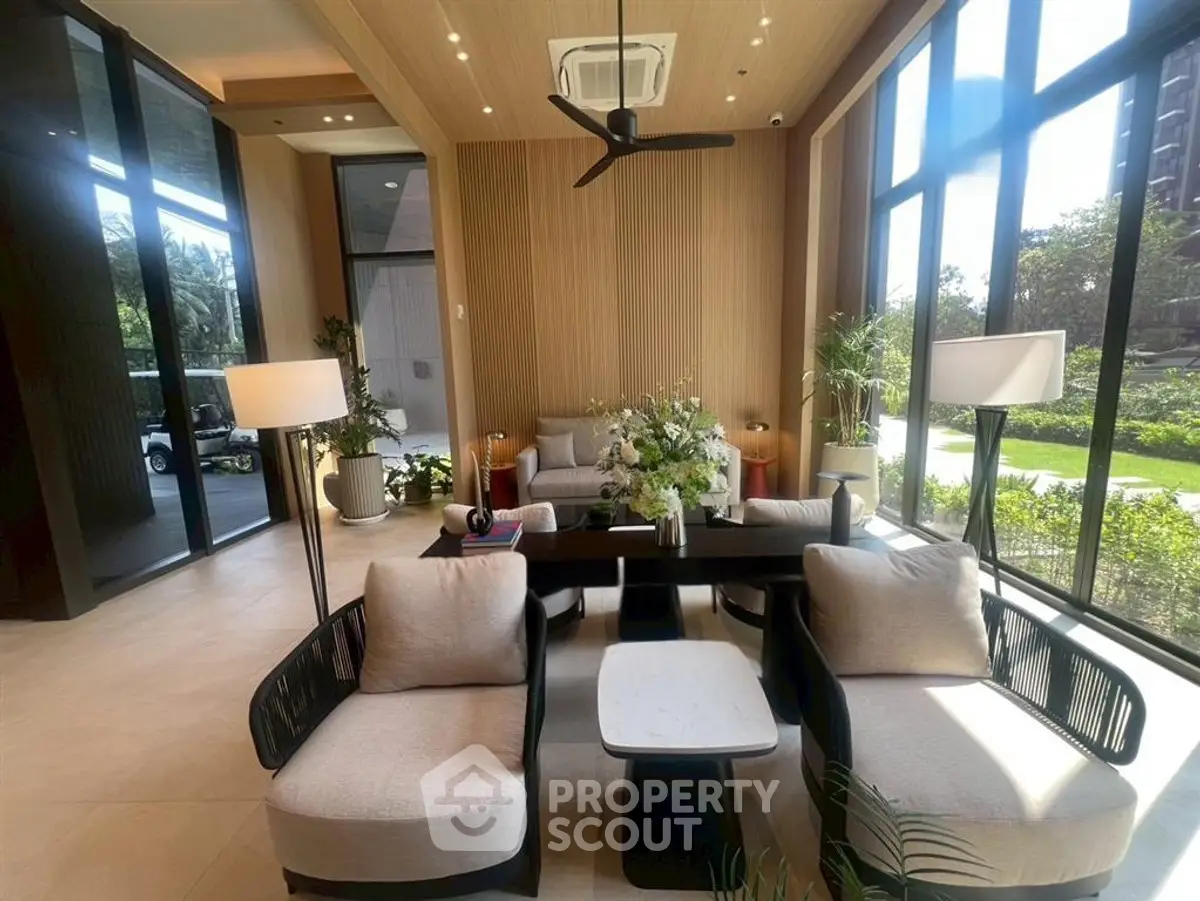 Luxurious modern living room with large windows and elegant furniture, offering a serene garden view.