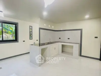 Spacious modern kitchen with sleek countertops and ample natural light.