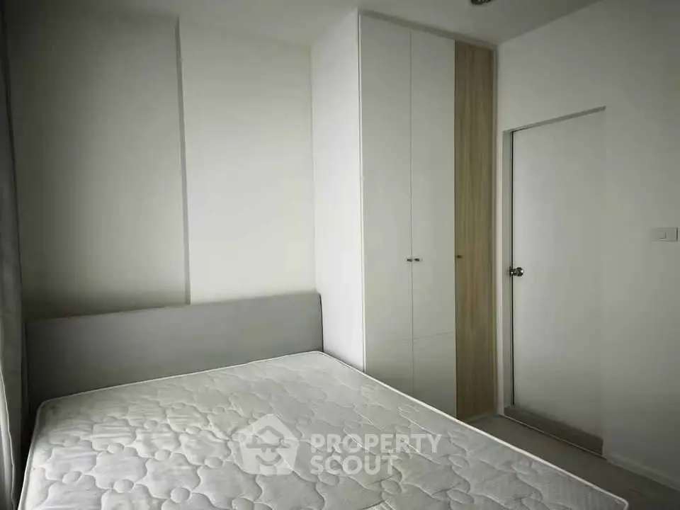 Modern minimalist bedroom with sleek built-in wardrobe and cozy bed setup.