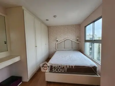 Cozy bedroom with large window and built-in wardrobe, perfect for natural light lovers.