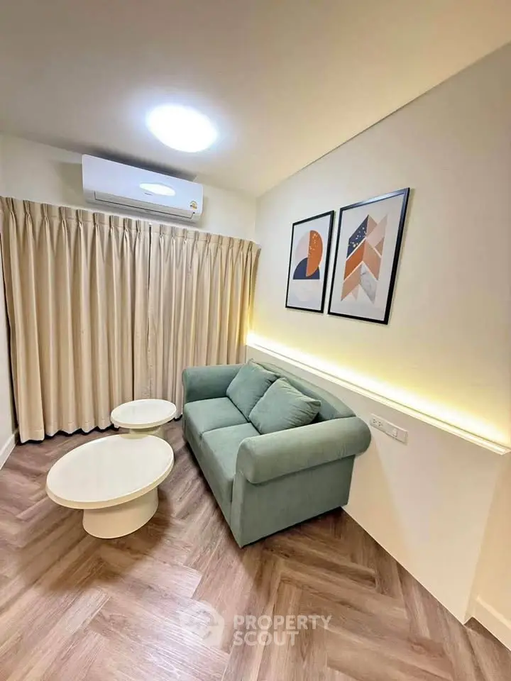 Modern living room with stylish sofa, round tables, and elegant wall art in cozy apartment.