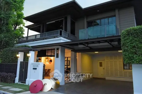Modern two-story house with spacious balcony and stylish exterior design.