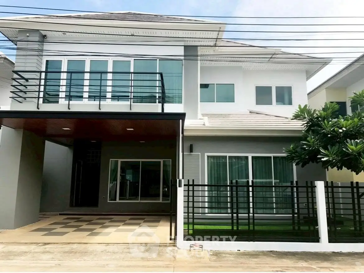 Modern two-story house with sleek design and spacious driveway in a suburban neighborhood.
