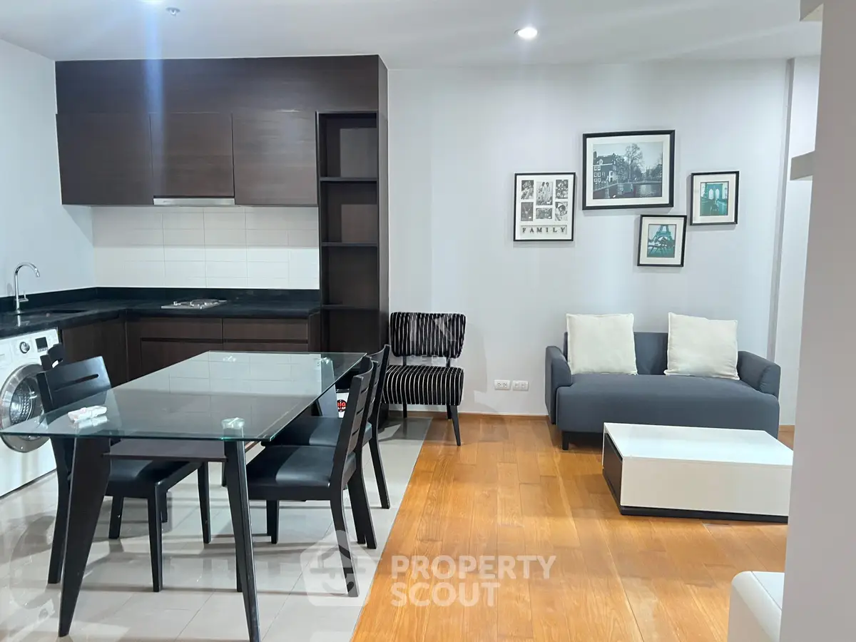 Modern open-layout living room with dining area and stylish kitchen in a contemporary apartment.
