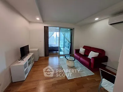 Modern living room with red sofa, TV, and balcony view in stylish apartment.
