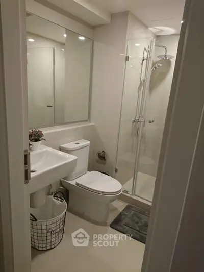 Modern bathroom with glass shower and sleek fixtures in a contemporary home.