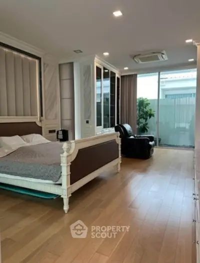 Spacious bedroom with elegant decor and large windows for natural light.