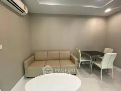 Modern living room with beige sofa and dining set, featuring sleek design and neutral tones.