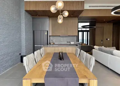Luxurious open-plan living and dining area with modern kitchen and elegant lighting.