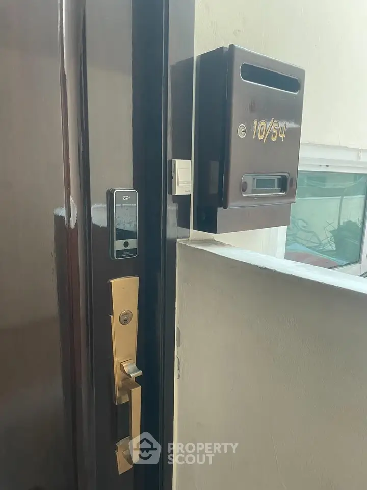 Modern apartment entrance with secure digital lock and mailbox, ideal for urban living.