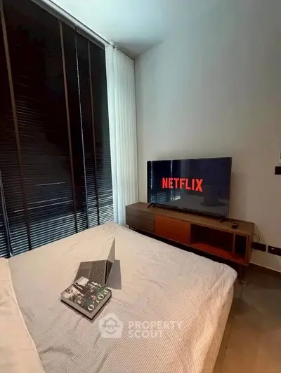 Modern bedroom with sleek TV setup and cozy bed, perfect for relaxation and entertainment.
