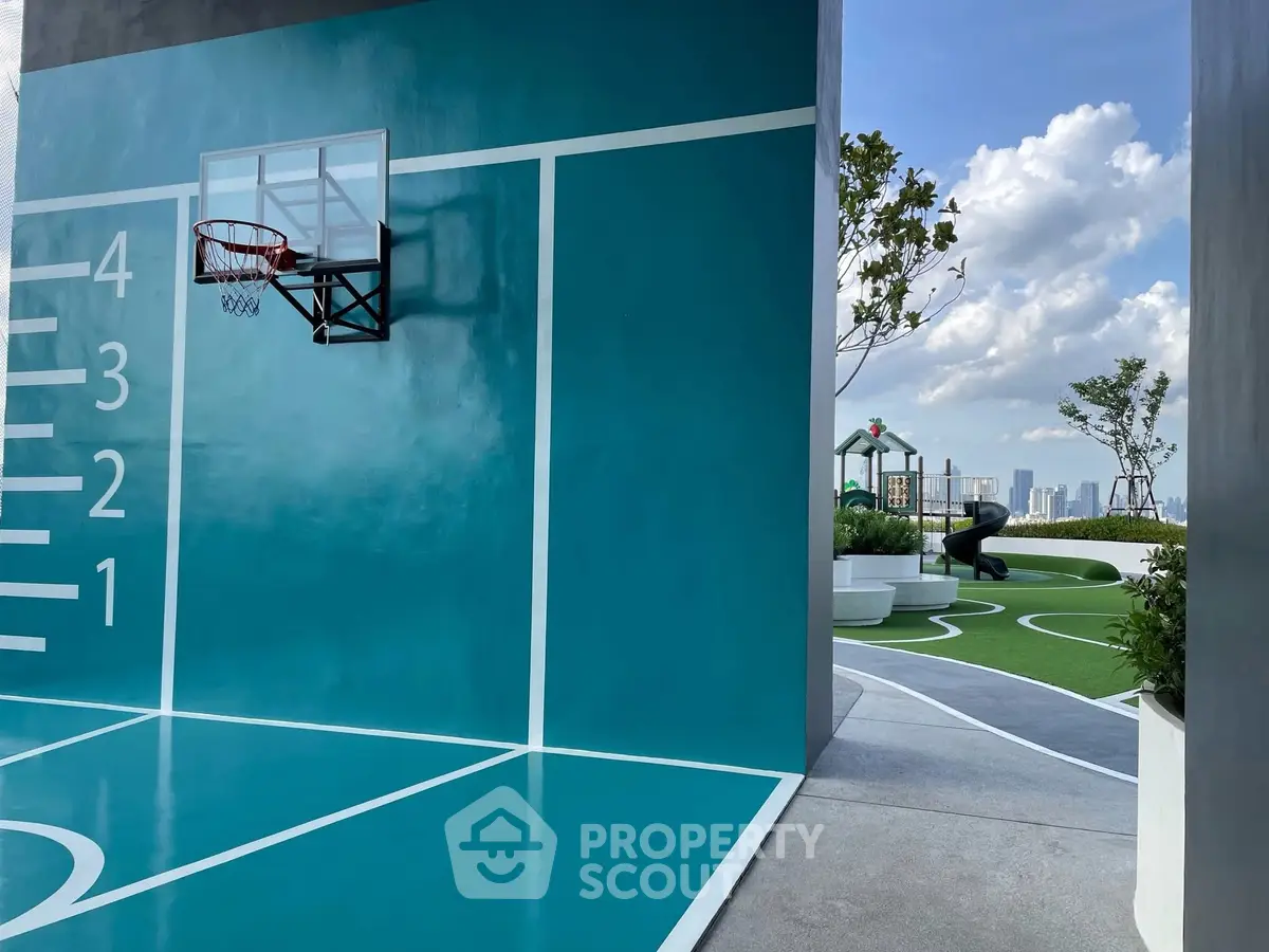 Modern rooftop basketball court with city skyline view and lush greenery.