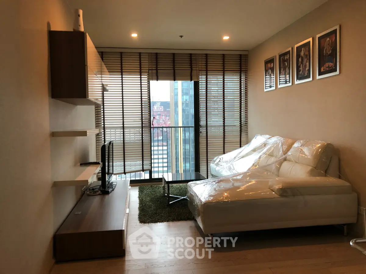 Modern living room with stylish decor and large windows offering city views.