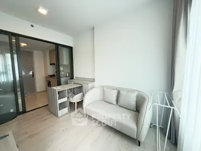 Modern living room with cozy sofa and open kitchen layout in a stylish apartment.