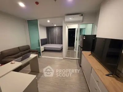 Modern studio apartment with open layout, featuring a cozy living area and sleek kitchen.