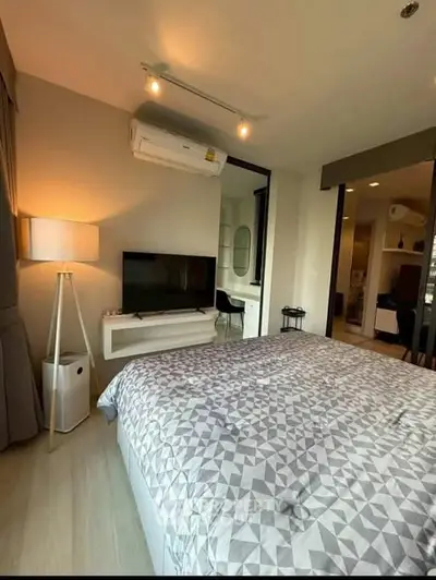Modern bedroom with stylish decor and cozy ambiance, featuring a TV and air conditioning.