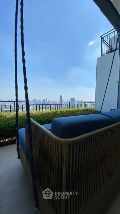 Stunning balcony view with cozy seating and city skyline backdrop.