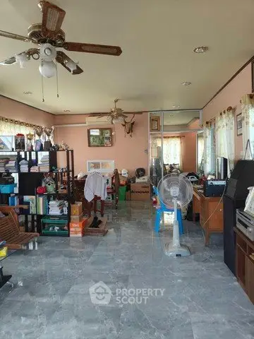 Spacious living room with ceiling fans and marble flooring, ideal for family gatherings.