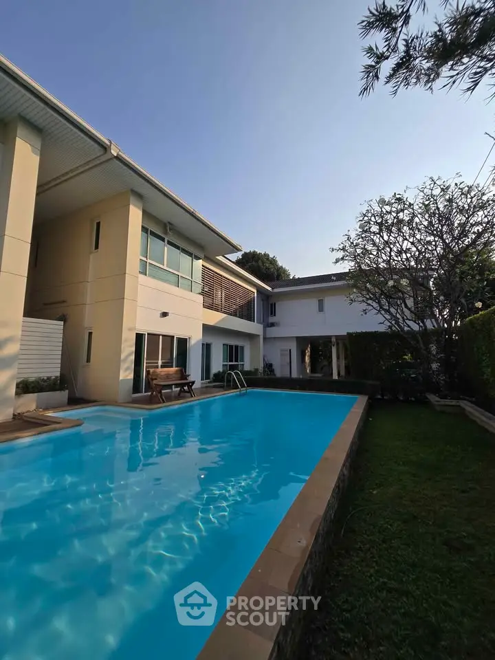 Luxurious modern home with a stunning private pool and lush garden, perfect for relaxation and entertainment.
