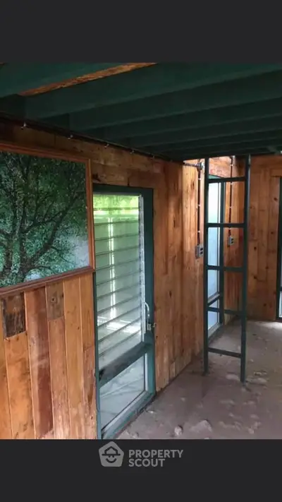 Rustic wooden interior with ladder and large window, ideal for creative renovation.