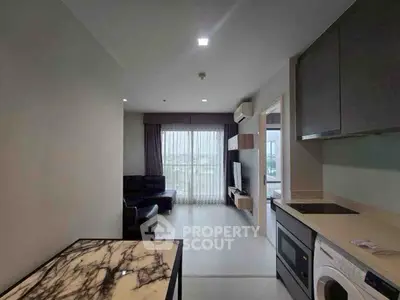 Modern apartment interior with open layout, featuring a stylish kitchen and cozy living area with city view.