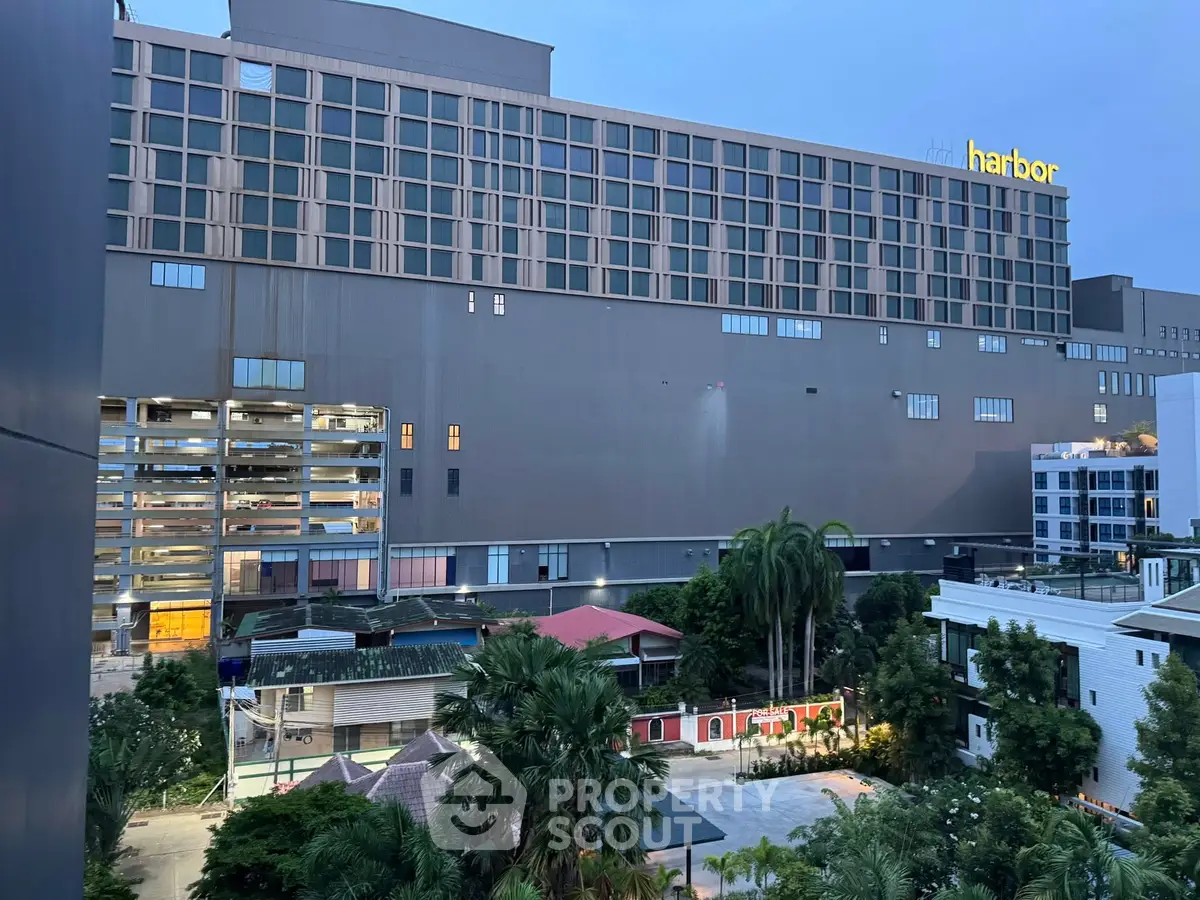 Modern urban building with lush greenery and parking area view