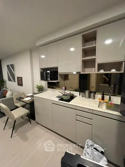 Modern kitchen with sleek cabinetry and dining area in contemporary apartment