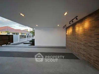 Spacious modern garage with brick accent wall and recessed lighting
