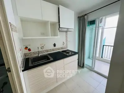 Modern kitchen with sleek cabinetry and balcony access in a stylish apartment.