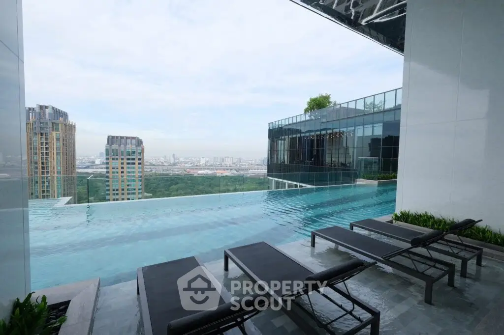 Luxurious rooftop infinity pool with stunning city skyline view, perfect for relaxation and leisure.