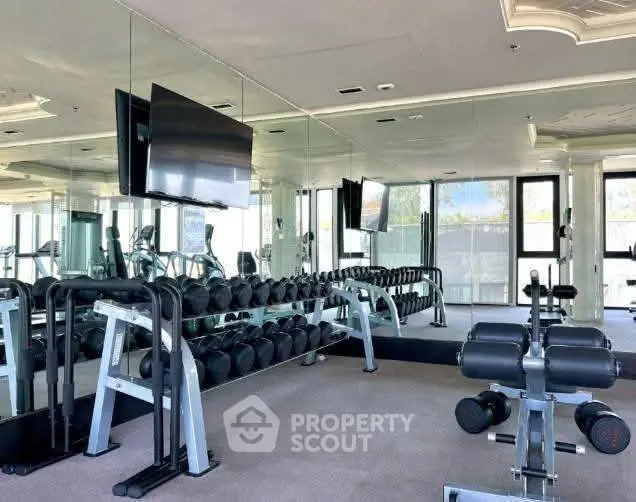 Spacious modern gym with mirrored walls and state-of-the-art equipment.