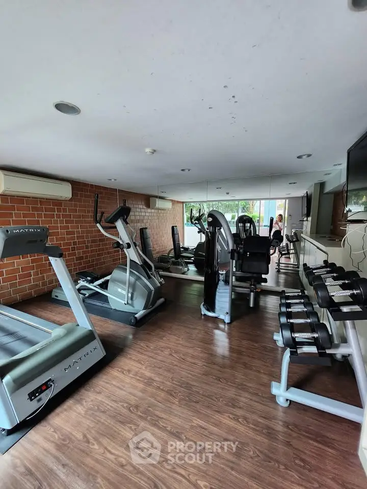 Modern gym with state-of-the-art equipment and mirrored walls in a residential building.