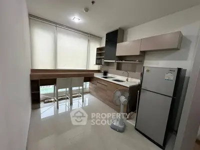 Modern kitchen with sleek cabinetry and dining area in a stylish apartment.