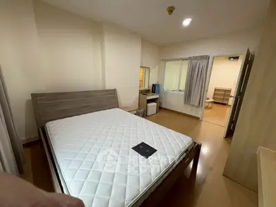 Spacious bedroom with modern furnishings and ensuite bathroom in a cozy apartment.