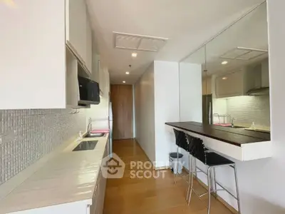 Modern kitchen with sleek design and open layout, featuring a breakfast bar and stylish seating.